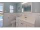 Bathroom with white vanity, toilet and shower; view of pool outside at 125 Ott Cir, Port Charlotte, FL 33952