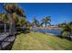 Scenic backyard view of canal, lush lawn and palms at 125 Ott Cir, Port Charlotte, FL 33952