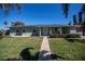 Single-story house with green exterior, walkway, and landscaping at 125 Ott Cir, Port Charlotte, FL 33952