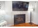 Living room fireplace with a stone surround, mounted TV, and hardwood flooring at 1311 Abscott St, Port Charlotte, FL 33952