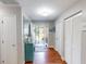 Hallway featuring hardwood floors, storage closets, and a turquoise accent cabinet near the front door at 1311 Abscott St, Port Charlotte, FL 33952