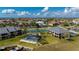 Scenic aerial view of community featuring a pool, tennis court, boat dock, and lush landscaping against a blue sky backdrop at 1335 Rock Dove Ct # 52, Punta Gorda, FL 33950