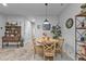 Charming dining area featuring a round wooden table, four chairs, and tasteful decor, adjacent to the kitchen and bathed in natural light at 16300 Coconut Palm Dr, Port Charlotte, FL 33953