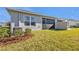 Exterior view of the house with a small yard, including a screened in patio and exterior AC unit at 16300 Coconut Palm Dr, Port Charlotte, FL 33953