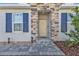 A cozy front porch with stone trim and professional landscaping leads to the home's front door at 16300 Coconut Palm Dr, Port Charlotte, FL 33953