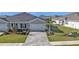 The two car garage is attached to the home with a brick paver driveway and professional landscaping at 16300 Coconut Palm Dr, Port Charlotte, FL 33953