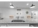 Close-up of a granite kitchen island with a sink and seating, complemented by modern pendant lighting and white cabinets at 16300 Coconut Palm Dr, Port Charlotte, FL 33953