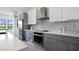 Modern kitchen with gray cabinets, white countertops, and herringbone backsplash at 16506 Cape Horn Blvd, Punta Gorda, FL 33955