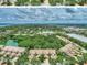 Aerial view of townhomes with lush greenery, ponds, and a glimpse of the scenic bay at 1710 Starling Dr # 102, Sarasota, FL 34231