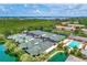 Aerial view of community tennis courts and a pool surrounded by waterfront views at 1710 Starling Dr # 102, Sarasota, FL 34231