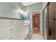 Light-filled bathroom featuring a double vanity, granite countertop, and access to a tiled shower at 1710 Starling Dr # 102, Sarasota, FL 34231