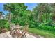 Outdoor patio with wooden table and seating surrounded by lush landscaping, creating a tranquil retreat at 1710 Starling Dr # 102, Sarasota, FL 34231