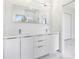 Bright white bathroom with double vanity and large mirror at 17200 Mint Ln, Punta Gorda, FL 33955