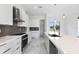 Modern kitchen with white cabinets and gray tile backsplash at 17200 Mint Ln, Punta Gorda, FL 33955