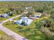 Aerial view of the home featuring a pool, boat cover, landscaping and mature trees on an oversized lot at 18181 Bly Ave, Port Charlotte, FL 33948