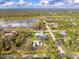 Beautiful aerial view of a property featuring a large lot, mature trees, and a nearby pond at 18181 Bly Ave, Port Charlotte, FL 33948