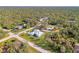 Aerial view of a charming home with a metal roof, surrounded by lush greenery and a well-manicured lawn at 18181 Bly Ave, Port Charlotte, FL 33948