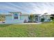 Light blue single-story home with a metal roof and landscaping at 18181 Bly Ave, Port Charlotte, FL 33948