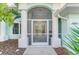 Charming front entrance with double doors, screened-in porch, and manicured landscaping at 18181 Bly Ave, Port Charlotte, FL 33948