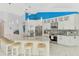 Bright kitchen with a marble countertop island, stainless steel appliances, white cabinetry, and modern lighting at 18181 Bly Ave, Port Charlotte, FL 33948