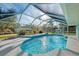 Gorgeous pool with a screen enclosure and a covered area featuring chairs for relaxation at 18181 Bly Ave, Port Charlotte, FL 33948