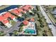 An aerial view of a quiet community featuring a pool and cabana near vibrant terracotta-roofed buildings at 1890 Deborah Dr # 6, Punta Gorda, FL 33950