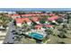 This aerial shot shows a community pool, cabana, palm trees, and the buildings in the community at 1890 Deborah Dr # 6, Punta Gorda, FL 33950