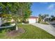 Charming home exterior featuring a well-manicured lawn, neatly trimmed hedges, and an attached two-car garage at 1890 Deborah Dr # 6, Punta Gorda, FL 33950