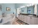 This main bathroom features a soaking tub, shower, and dual vanities with a dark stone countertop and white cabinetry at 1890 Deborah Dr # 6, Punta Gorda, FL 33950