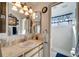 Well-lit bathroom features a vanity with a sink and a shower with a blue patterned curtain at 20352 Tappan Zee Dr, Port Charlotte, FL 33952