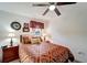 Bedroom with ceiling fan, red patterned bedspread, wood-look floors, and neutral walls and trim at 20352 Tappan Zee Dr, Port Charlotte, FL 33952