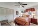 Cozy bedroom with a ceiling fan, a bed with red patterned bedding, and a window with red curtains at 20352 Tappan Zee Dr, Port Charlotte, FL 33952