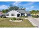 Charming single-story home with a circular flower bed and a driveway leading to an attached two-car garage at 20352 Tappan Zee Dr, Port Charlotte, FL 33952