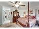 Bright main bedroom featuring a four poster bed, ceiling fan, and access to hallway at 20352 Tappan Zee Dr, Port Charlotte, FL 33952