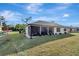 View of the screened-in lanai with a well-maintained lawn and simple landscaping surrounding the home at 20352 Tappan Zee Dr, Port Charlotte, FL 33952