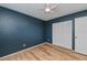 Bedroom with dark blue walls, wood flooring, a ceiling fan and a white closet at 20431 Calder Ave, Port Charlotte, FL 33954