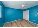 Bedroom with bright blue walls, a ceiling fan, wood flooring and a white closet at 20431 Calder Ave, Port Charlotte, FL 33954