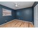 Bedroom with dark blue walls, a window with blinds, wood flooring and a white closet at 20431 Calder Ave, Port Charlotte, FL 33954