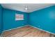 Bright bedroom featuring blue walls, a ceiling fan and wood-look flooring at 20431 Calder Ave, Port Charlotte, FL 33954