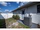 Exterior view showcases a side entrance, AC unit, and white fencing, enhancing privacy and functionality at 20431 Calder Ave, Port Charlotte, FL 33954