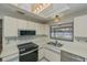 Well-lit kitchen showcasing stainless appliances, modern lighting fixtures and neutral countertops at 20431 Calder Ave, Port Charlotte, FL 33954