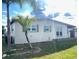 Side view of the house showcasing its light-colored exterior and landscaping at 21157 Midway Blvd, Port Charlotte, FL 33952