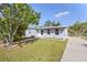 Charming single-story home with fresh landscaping, gray exterior, and a well-manicured lawn at 21274 Gladis Ave, Port Charlotte, FL 33952