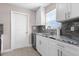 Bright kitchen featuring white cabinetry, granite countertops, stainless steel appliances, and tile backsplash at 21274 Gladis Ave, Port Charlotte, FL 33952