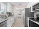 Modern kitchen featuring stainless steel appliances, granite countertops, and white cabinets at 21274 Gladis Ave, Port Charlotte, FL 33952