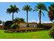 Inviting community entrance sign with manicured landscaping and mature palm trees on a sunny day at 21370 Harborside Blvd, Port Charlotte, FL 33952