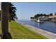 Scenic waterfront view with lush greenery, a boat cruising by, and picturesque waterfront homes at 21370 Harborside Blvd, Port Charlotte, FL 33952