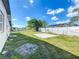 Large backyard featuring a sand area and chain-link/white fencing, perfect for outdoor activities at 21402 Meehan Ave, Port Charlotte, FL 33952