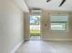 Airy bedroom with tile floors, modern mini split AC, and backyard access through a glass door at 21402 Meehan Ave, Port Charlotte, FL 33952