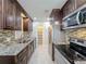 Modern kitchen with granite countertops, stainless appliances, and a large pantry at 21402 Meehan Ave, Port Charlotte, FL 33952